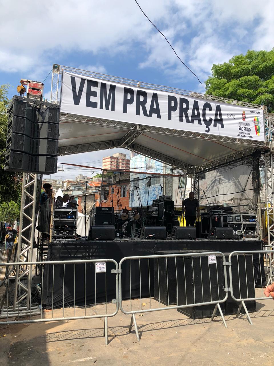 Imagem do palco do coopera com uma faixa escrito "VEM PRA PRAÇA" 